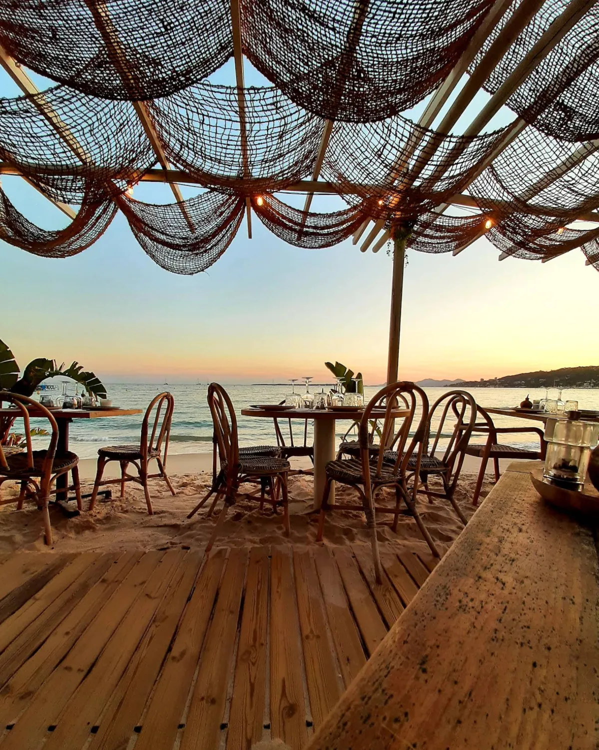A beachside restaurant set for dinner at dusk