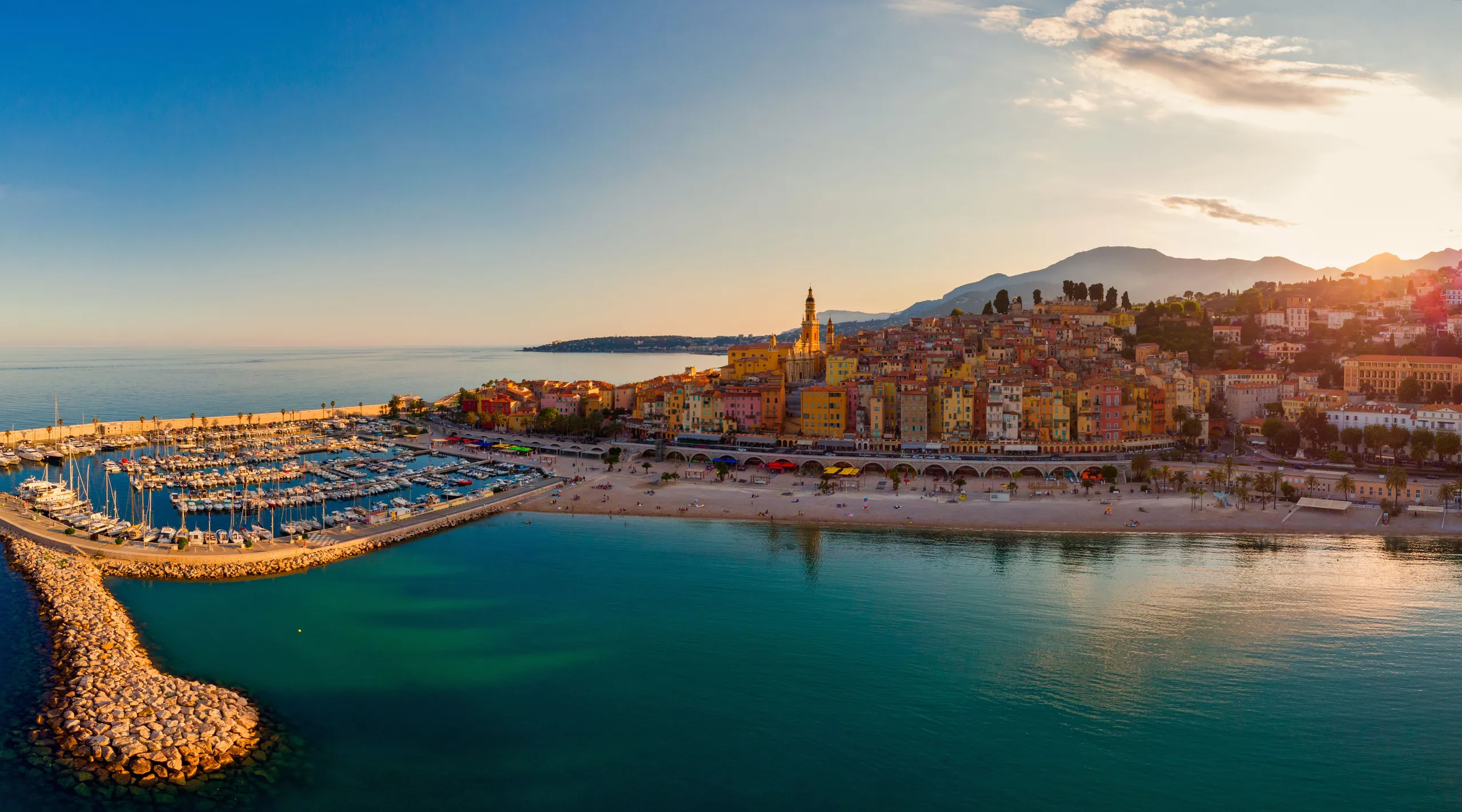 The French Riviera coastline at golden hour, the sea meeting terraced hills